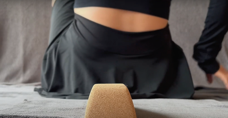 Person using a cork heart opener block on the floor.